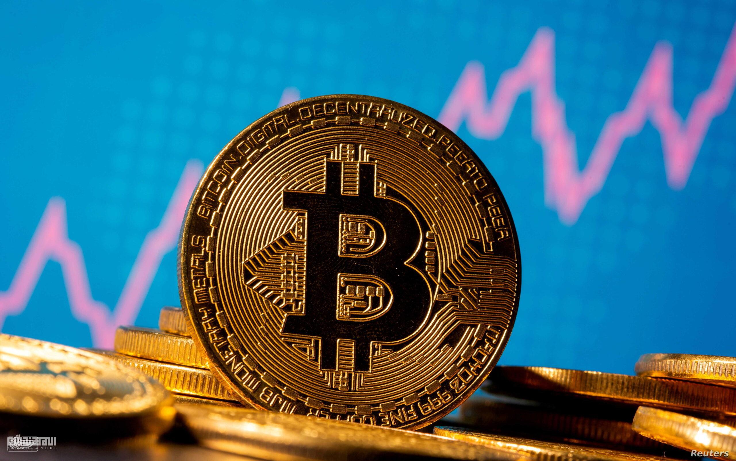 FILE PHOTO: A representation of virtual currency bitcoin is seen in front of a stock graph سعر البيتكوين الحالي بالدولار